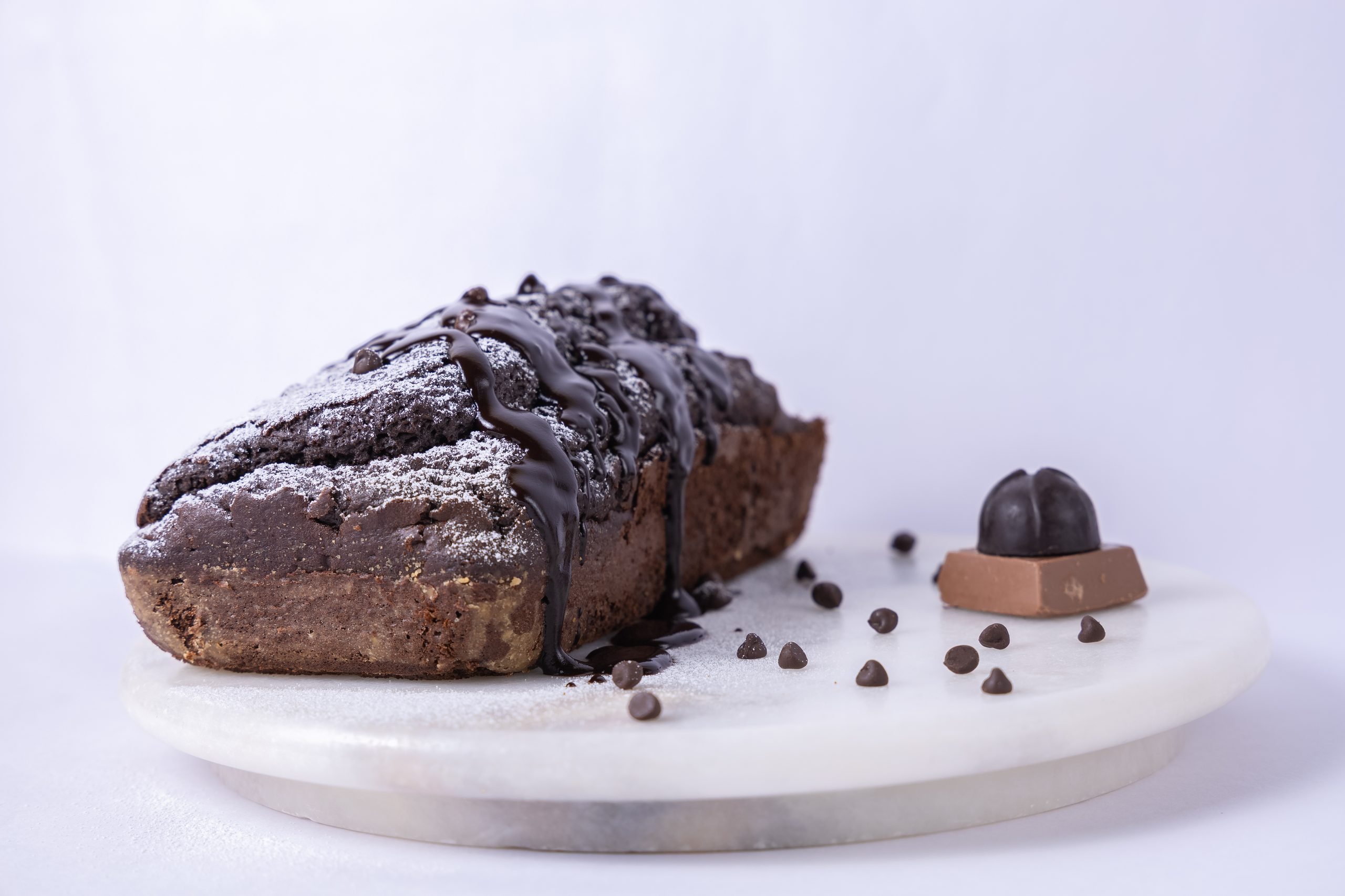 Chocolate loaf on a marble plate against white