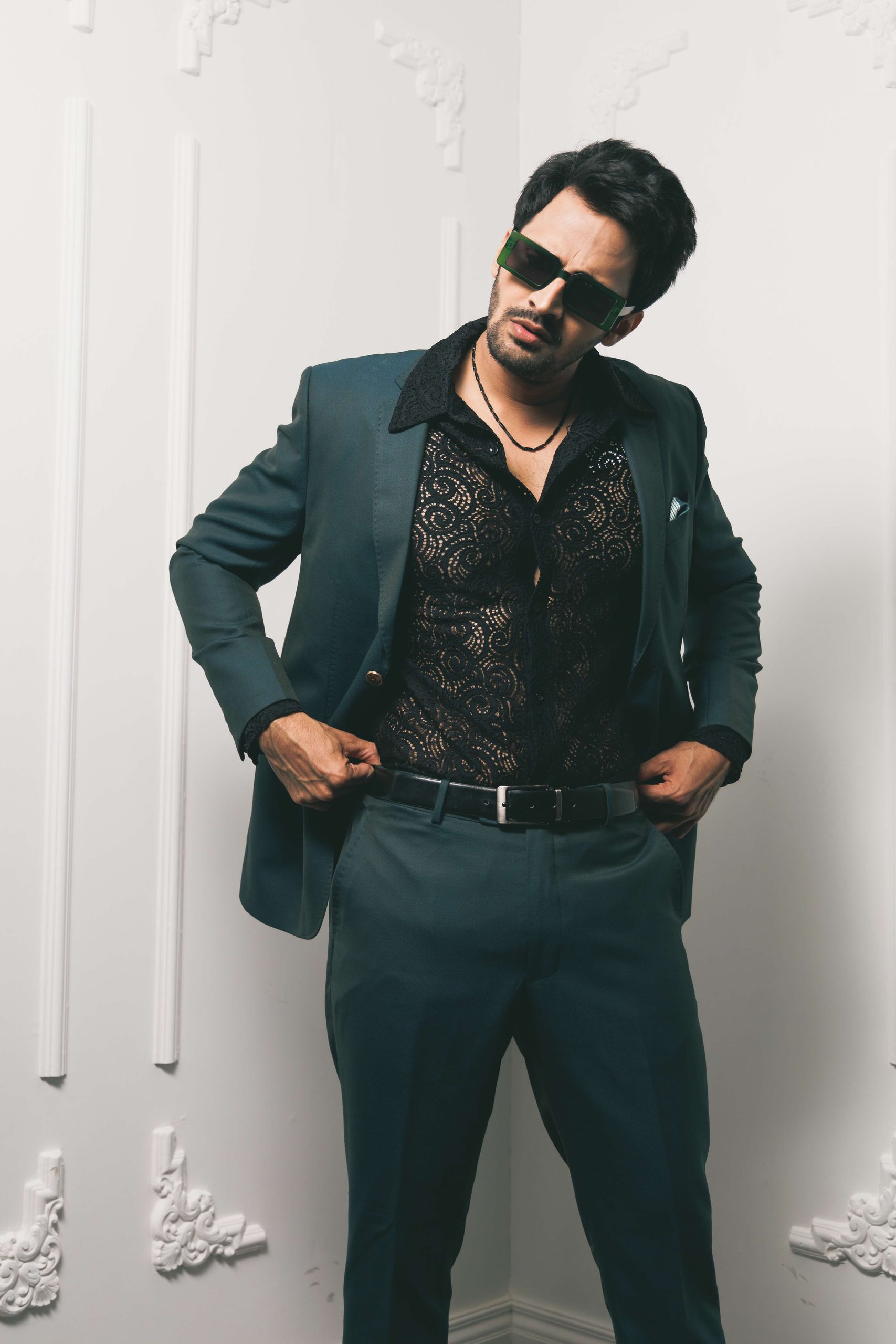 Model in a green suit against a white panelled wall